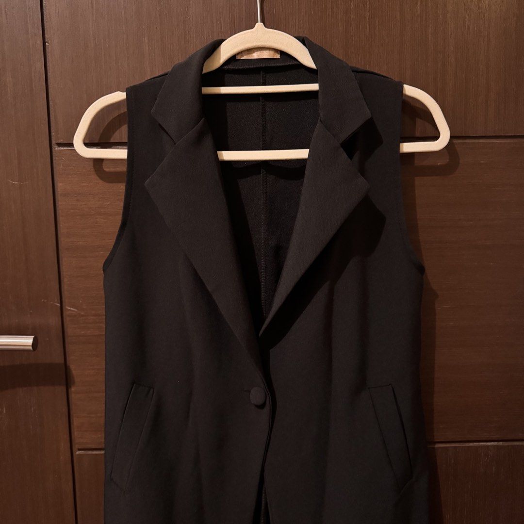 Black Sleeveless Long Vest Coat Blazer (Category: Sleeveless) located in Quezon City. Submitted by ianne.declutter (Listing ID 1470049951, Image 2). Description: - Style: Black sleeveless long vest with lapel collar - Closure: Single front button - Pockets: Two deep side pockets - Fit: Mid-thigh length, lightweight structured fabric - Origin: Korean brand - Condition: Clean, no tears or loose threads - Versatility: Great layering piece over shirt