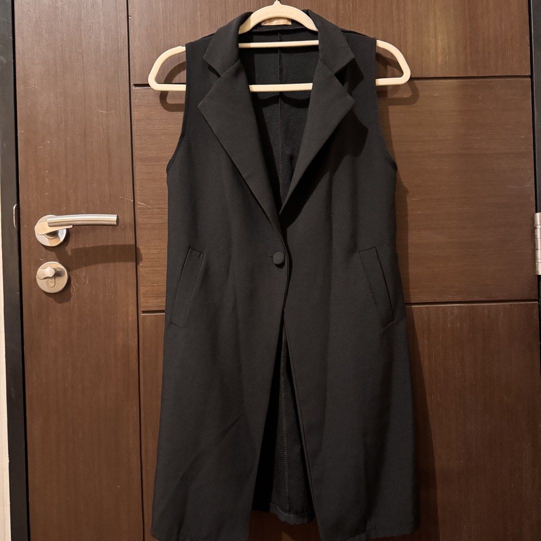 Black Sleeveless Long Vest Coat Blazer (Category: Sleeveless) located in Quezon City. Submitted by ianne.declutter (Listing ID 1470049951, Image 1). Description: - Style: Black sleeveless long vest with lapel collar - Closure: Single front button - Pockets: Two deep side pockets - Fit: Mid-thigh length, lightweight structured fabric - Origin: Korean brand - Condition: Clean, no tears or loose threads - Versatility: Great layering piece over shirt