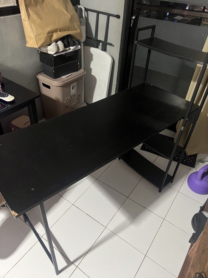 Black Study Desk with Built-in Shelves (Category: Tables & Sets) located in Quezon City. Submitted by vieee_ (Listing ID 1470062752, Image 3). Description: - Sleek black wooden desktop with sturdy metal legs and built-in vertical shelves - Generous surface area ideal for computer setups, books, and study materials - Solid metal crossbar support at the back for maximum stability - Minor flaw: Small corner chip near the front edge (clearly visible 
