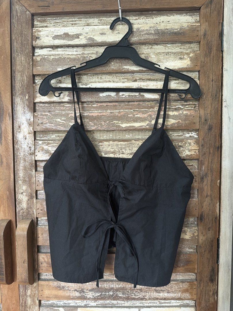 Black tie front camisole spaghetti strap top (Category: Sleeveless) located in Manila. Submitted by cb_____ (Listing ID 1469968556, Image 1). Description: - Color: Solid black - Style: Camisole top with thin spaghetti straps - Closure: Cute double fabric ties at the front - Fit: Elastic band at the top back edge for comfort and a secure fit - Material: Simple, lightweight, and breathable fabric - Versatility: Great for casual daytime wear, layeri