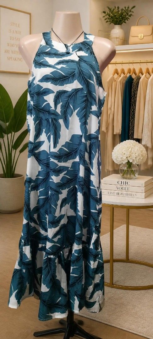 Blue and White Leaf Print Maxi Dress (Category: Dresses) located in Manila. Submitted by gracjam_27 (Listing ID 1470031580, Image 1). Description: - Style: Long sleeveless maxi dress with halter neckline - Pattern: Bold blue and white tropical leaf design - Features: Relaxed flowing fit, lightweight fabric, cute ruffled hem - Best For: Warm weather, beach vacations, and casual outings - Fit: Easy slip-on design for ultimate comfort.
