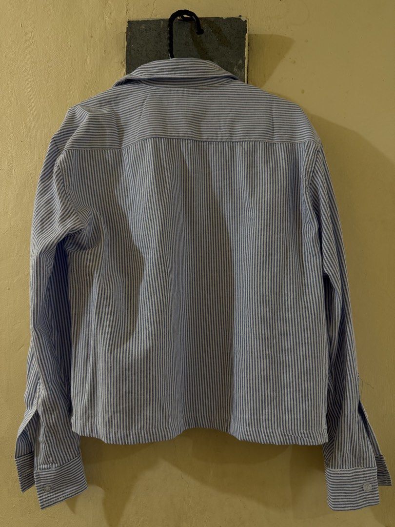 Blue Cropped Longsleeve (Category: Tshirts & Polo Shirts ) located in Las Pinas. Submitted by rareriroruru (Listing ID 1470054511, Image 2). Description: - Size: Small - Length: 21 in - Width: 20 in - Classic blue and white vertical stripe pattern - Lightweight 100% cotton material ideal for layering - Features a lapel collar, front button closure, and long sleeves with wide buttoned cuffs - Regular hip-length hemline - Versatile piece for casual