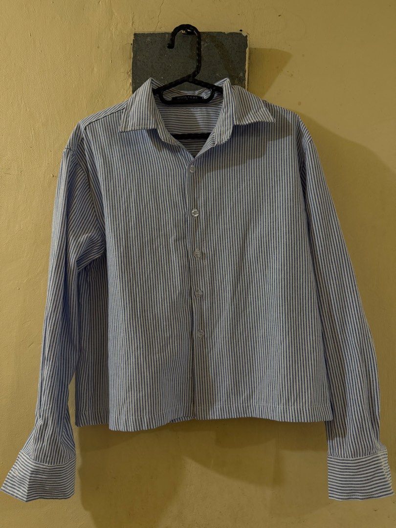 Blue Cropped Longsleeve (Category: Tshirts & Polo Shirts ) located in Las Pinas. Submitted by rareriroruru (Listing ID 1470054511, Image 1). Description: - Size: Small - Length: 21 in - Width: 20 in - Classic blue and white vertical stripe pattern - Lightweight 100% cotton material ideal for layering - Features a lapel collar, front button closure, and long sleeves with wide buttoned cuffs - Regular hip-length hemline - Versatile piece for casual