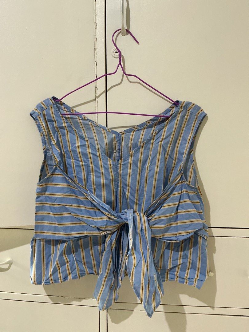 Blue striped crop top with front tie detail (Category: Blouses) located in Rizal. Submitted by kyliemaine (Listing ID 1470030465, Image 2). Description: - Style: Blue and yellow striped sleeveless crop top - Design: V-neckline on front and back with a stylish front tie-knot - Material: Lightweight and breathable, ideal for warm weather - Fit: Comfortable and pairs easily with high-waisted shorts or jeans.