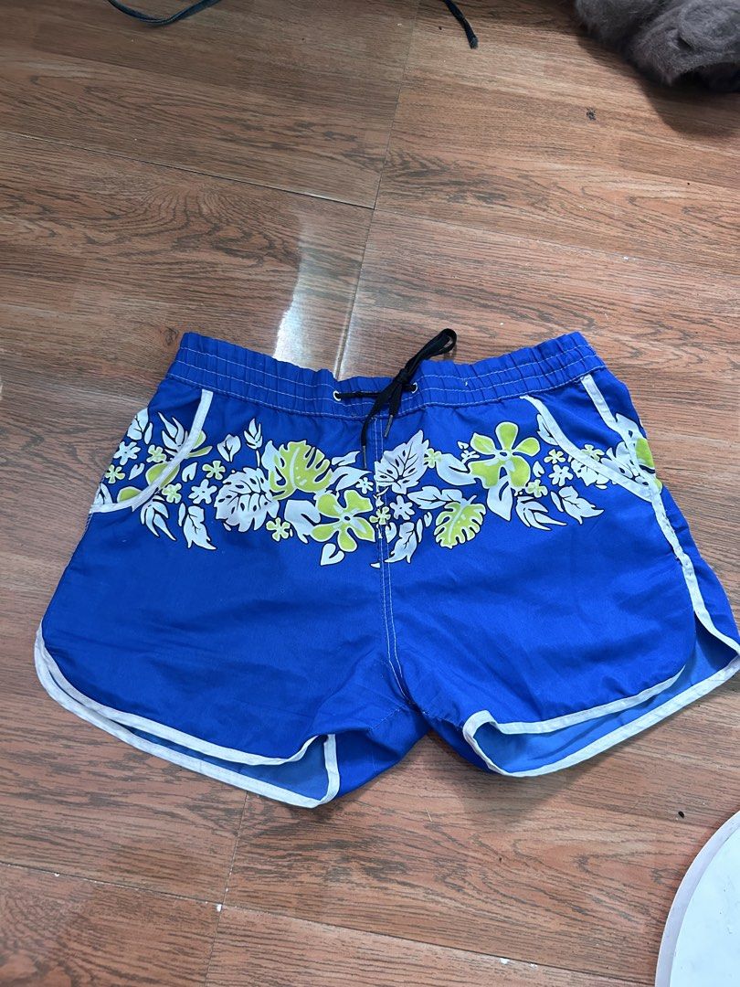 Blue swim short (Category: Shorts) located in Manila. Submitted by lovely.453 (Listing ID 1469994317, Image 1). Description: - Color: Bright blue with white and lime adjustable waist size 25-30 green tropical flower and leaf print - Features: Elastic waistband with black adjustable drawstring - Pockets: Two front pockets with white piping detail - Design: Stylish curved hems trimmed with white piping - Material: Lightweight fabric, ideal for swim