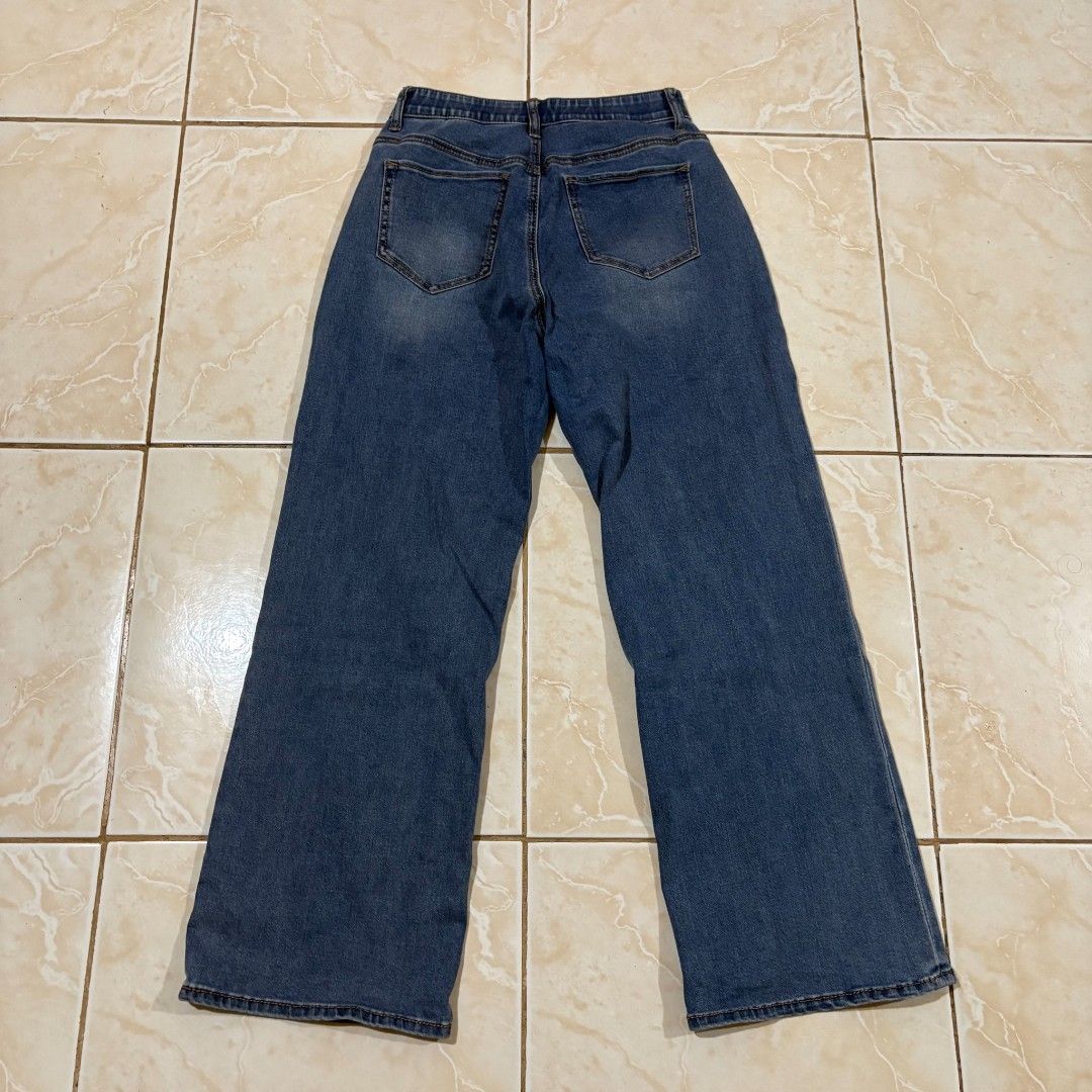 Blue Wide Leg Denim Jeans (Category: Jeans) located in El Salvador. Submitted by pretiezt2001 (Listing ID 1470033548, Image 2). Description: - Style: High-rise, wide-leg denim jeans - Wash: Medium wash blue - Closure: Button and zip fly - Design: Classic 5-pocket style with trendy front stitched seams - Comfort: Hidden elastic band inside the back waistband for a better fit - Versatility: Perfect for pairing with basic tees and crop tops.