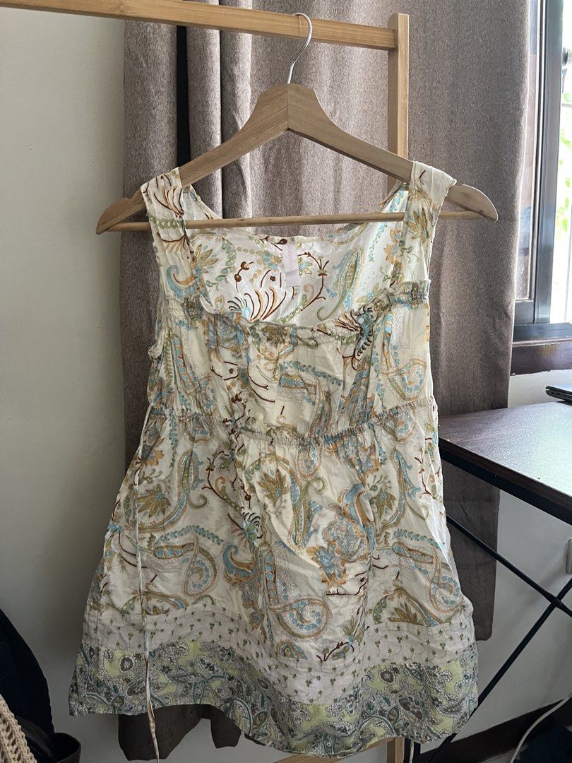 Boho Paisley Print Sleeveless Tunic Top (Category: Sleeveless) located in Manila. Submitted by una.dio (Listing ID 1469995902, Image 1). Description: - Style: Casual summer dress - Color/Pattern: Cream background with blue, brown, and green paisley - Material: Lightweight, comfortable fabric - Design: Wide scoop neckline, thick straps, and gathered waist with tie details - Detail: Contrasting border pattern on the bottom hem - Condition: Excellen