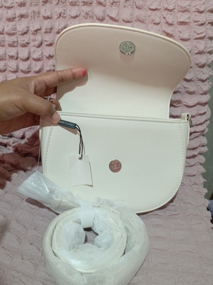 Bostanten White Studded Crossbody Bag (Category: Cross-body Bags) located in Caloocan City. Submitted by micheshop_1 (Listing ID 1470092574, Image 2). Description: - Brand: Bostanten crossbody bag - Color: White - Closure: Studded flap with magnetic snap - Strap: Adjustable and still wrapped in plastic - Interior: Fabric-lined with card slots and a zipper pocket - Condition: Brand new with tags attached, exceptionally clean inside and out.