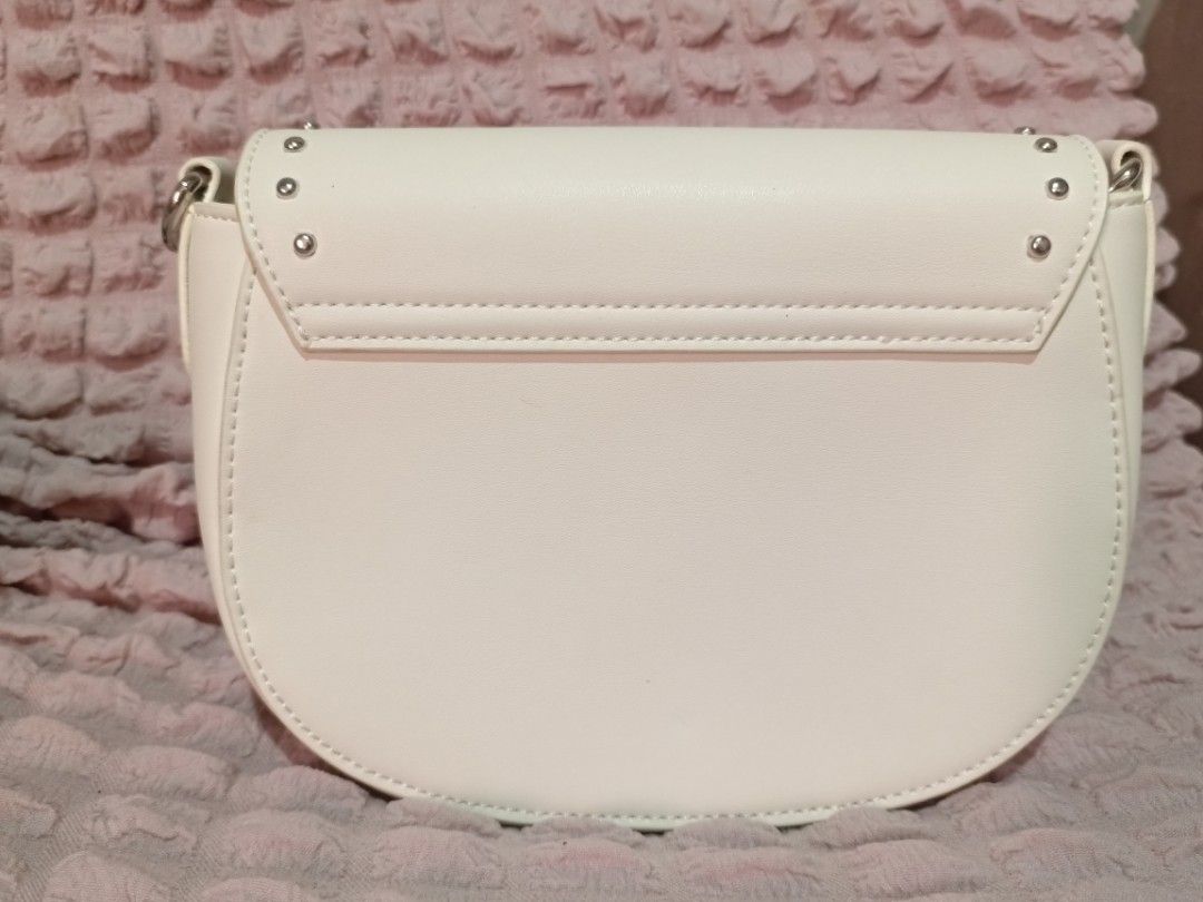 Bostanten White Studded Crossbody Bag (Category: Cross-body Bags) located in Caloocan City. Submitted by micheshop_1 (Listing ID 1470092574, Image 3). Description: - Brand: Bostanten crossbody bag - Color: White - Closure: Studded flap with magnetic snap - Strap: Adjustable and still wrapped in plastic - Interior: Fabric-lined with card slots and a zipper pocket - Condition: Brand new with tags attached, exceptionally clean inside and out.
