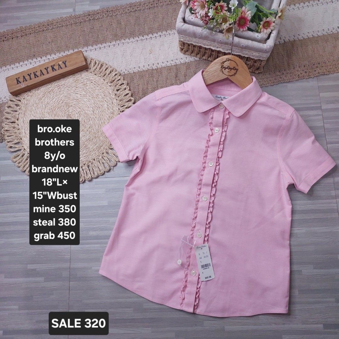 Brooks Brothers Pink Ruffle Blouse 8Y (Category: Babies & Kids Fashion) located in Subic. Submitted by kukay0521 (Listing ID 1470077032, Image 1). Description: - Brand: Brooks Brothers - Color: Pink - Size: Fits ~8 years old (18" length, 15" bust) - Material: 100% Cotton, machine washable - Condition: Brand new with tags (BNWT) - Details: Short sleeves, classic collar, cute ruffle placket.