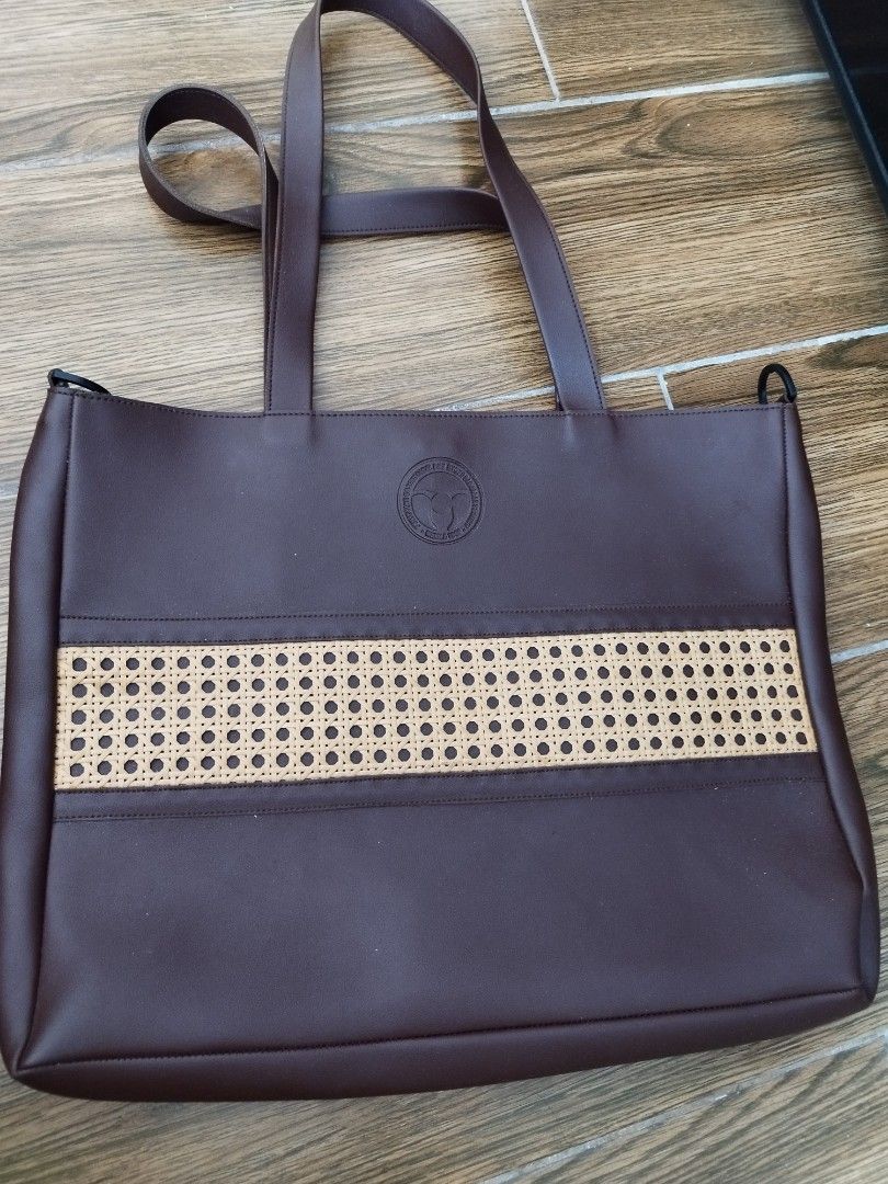 Brown Leather Tote Bag with Woven Panel (Category: Tote Bags) located in Cavite. Submitted by RAJATREASUREBOX (Listing ID 1469990511, Image 1). Description: - Dark brown faux leather tote bag with comfortable shoulder straps - Stylish centre stripe with a woven rattan pattern - Features a debossed circular logo stamp: Philippine Obstetrical and Gynecological Society Manila 1946 - Clean beige fabric interior with one open slip pocket - Pristine ex
