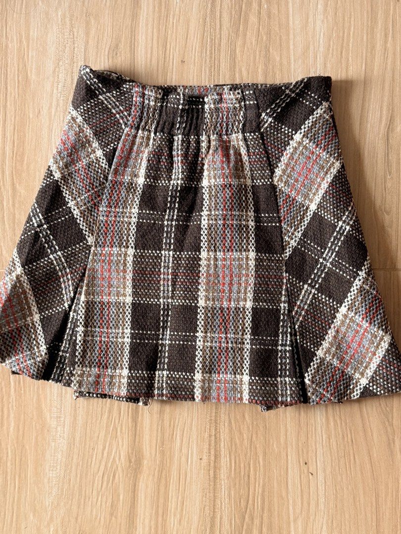 Brown Plaid Tweed Mini Skirt with Inner Lining (Category: Skirts) located in Agdangan. Submitted by onahhhh (Listing ID 1469952539, Image 2). Description: - Style: Short pleated tweed mini skirt - Pattern: Brown plaid with white, blue, and red check - Material: Thick woven fabric, fully lined with smooth brown fabric - Comfort: Hidden elastic waistband at the back - Season: Ideal for autumn and winter layering.