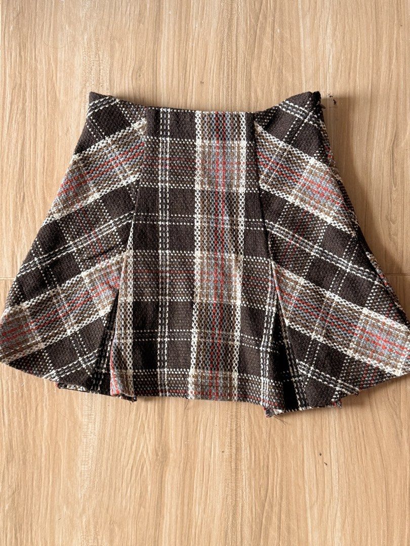 Brown Plaid Tweed Mini Skirt with Inner Lining (Category: Skirts) located in Agdangan. Submitted by onahhhh (Listing ID 1469952539, Image 1). Description: - Style: Short pleated tweed mini skirt - Pattern: Brown plaid with white, blue, and red check - Material: Thick woven fabric, fully lined with smooth brown fabric - Comfort: Hidden elastic waistband at the back - Season: Ideal for autumn and winter layering.