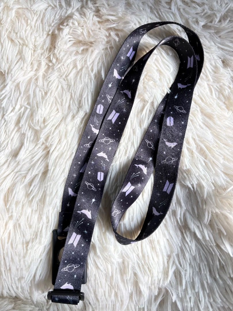 BTS Armybomb Lightstick Holder Strap for Concert (Category: K-Wave Merchandise) located in Manila. Submitted by ladyoflight (Listing ID 1470101768, Image 1). Description: - Official BTS Whalien 52 space design featuring stars, planets, whales, and the BTS logo - Stylish black and purple colorway - Equipped with a sturdy black plastic buckle and clip - Versatile use for ID badges, keys, or concert passes.