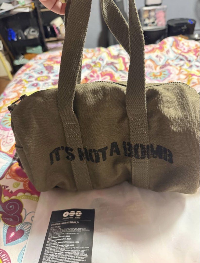 BTS Official Light Stick Bag IT'S NOT A BOMB (Category: Shoulder Bags) located in Manila. Submitted by rkfevans325 (Listing ID 1470058097, Image 2). Description: - Official BTS World Tour Arirang light stick bag - Color: Olive green canvas fabric - Front design features 'IT'S NOT A BOMB' text with a small branding logo on the back - Includes dual top handles and an adjustable strap for versatile carrying - Brand new with original tag and plastic 