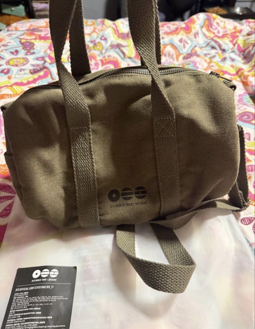BTS Official Light Stick Bag IT'S NOT A BOMB (Category: Shoulder Bags) located in Manila. Submitted by rkfevans325 (Listing ID 1470058097, Image 3). Description: - Official BTS World Tour Arirang light stick bag - Color: Olive green canvas fabric - Front design features 'IT'S NOT A BOMB' text with a small branding logo on the back - Includes dual top handles and an adjustable strap for versatile carrying - Brand new with original tag and plastic 