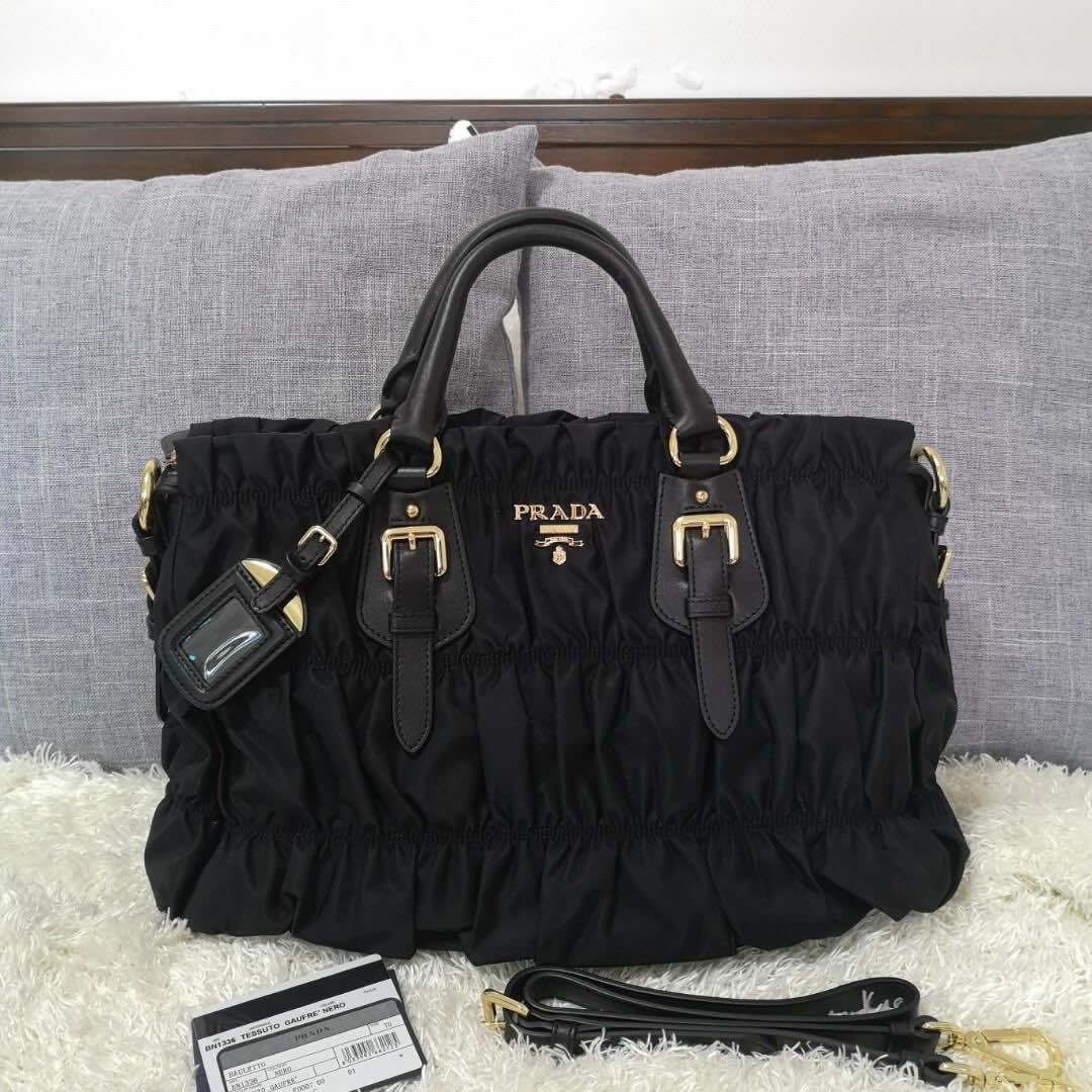 BUNDLE Prada Black Nylon Handbags (Category: Luxury Bags & Wallets) located in Makati City. Submitted by mariaasevilla0622eb (Listing ID 1469967853, Image 3). Description: - Authentic black Prada nylon handbags (Choice of 2 distinct styles) - Left Bag: Features elegant gathered ruching, luxury gold hardware, dual buckled straps, and a hanging clochette - Right Bag: Features classic dual top handles, a functional front flap pocket, and the iconic 