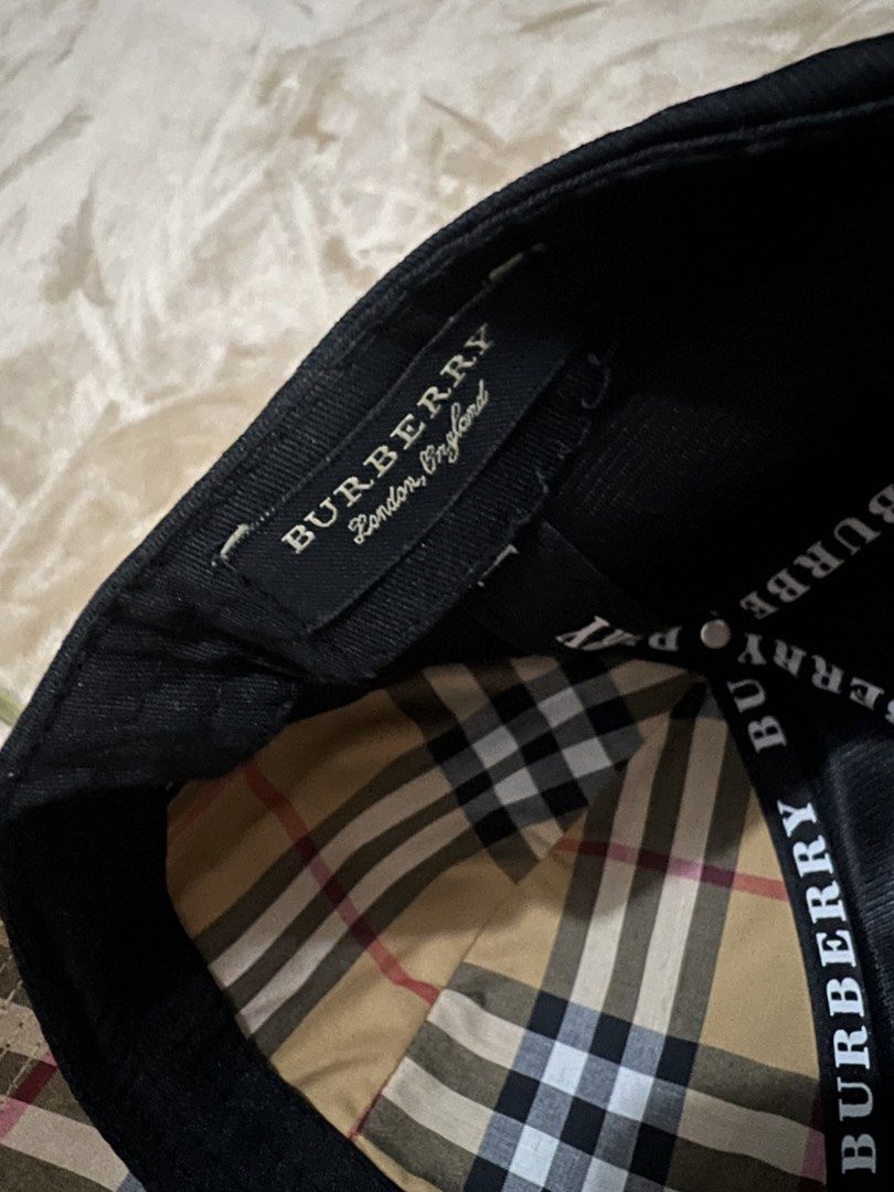 Burberry Black TB Monogram Baseball Cap (Category: Caps & Hats) located in Binan City. Submitted by thetidyqueen (Listing ID 1470076472, Image 3). Description: - Brand: Burberry - Color: Black with raised tonal TB monogram on the front - Brim: Underside features the classic vintage check pattern - Details: Branded interior strap tape and official London England tag - Fit: Adjustable strap at the back for a custom fit - Condition: Excellent, 100% 