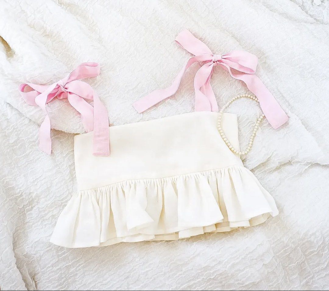 Calle Lily Pink Strap Peplum Top Medium (Category: Sleeveless) located in Makati City. Submitted by biancabuysells (Listing ID 1470035879, Image 3). Description: - Brand/Style: Calle Lily sleeveless top - Color: Creamy off-white (color might be off in the actual photo pls see photo grabbed from Calle Lily page for accurate color) - Size: Medium - Details: Adjustable pink ribbon shoulder straps, gathered peplum hem, low scoop back - Closure: Conce