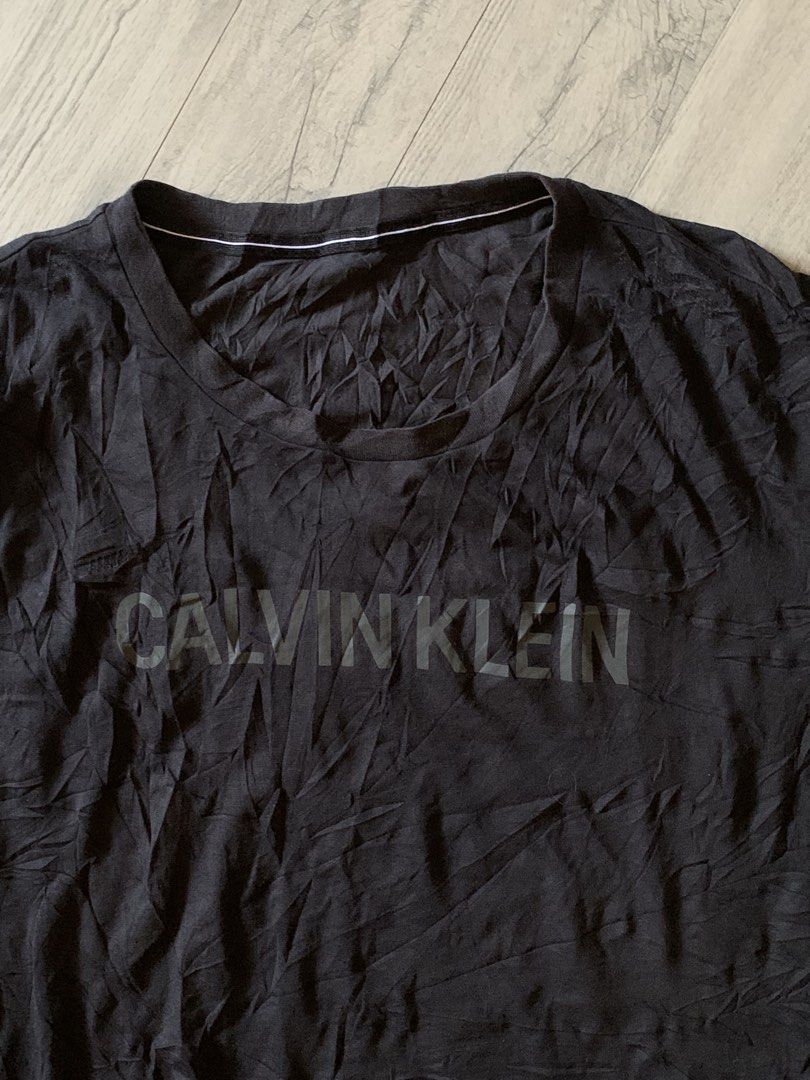 Calvin Klein Black Logo T-Shirt (Category: Activewear) located in Manila. Submitted by true_dailylifestyle (Listing ID 1470062446, Image 3). Description: - Brand: Calvin Klein - Color: Classic Black - Size: XXL (Regular Fit) - Design: Bold tonal chest logo with small 'ck' sleeve detail - Neckline: Crew neck - Style Code: J318288 - Condition: 100% authentic and well-maintained.