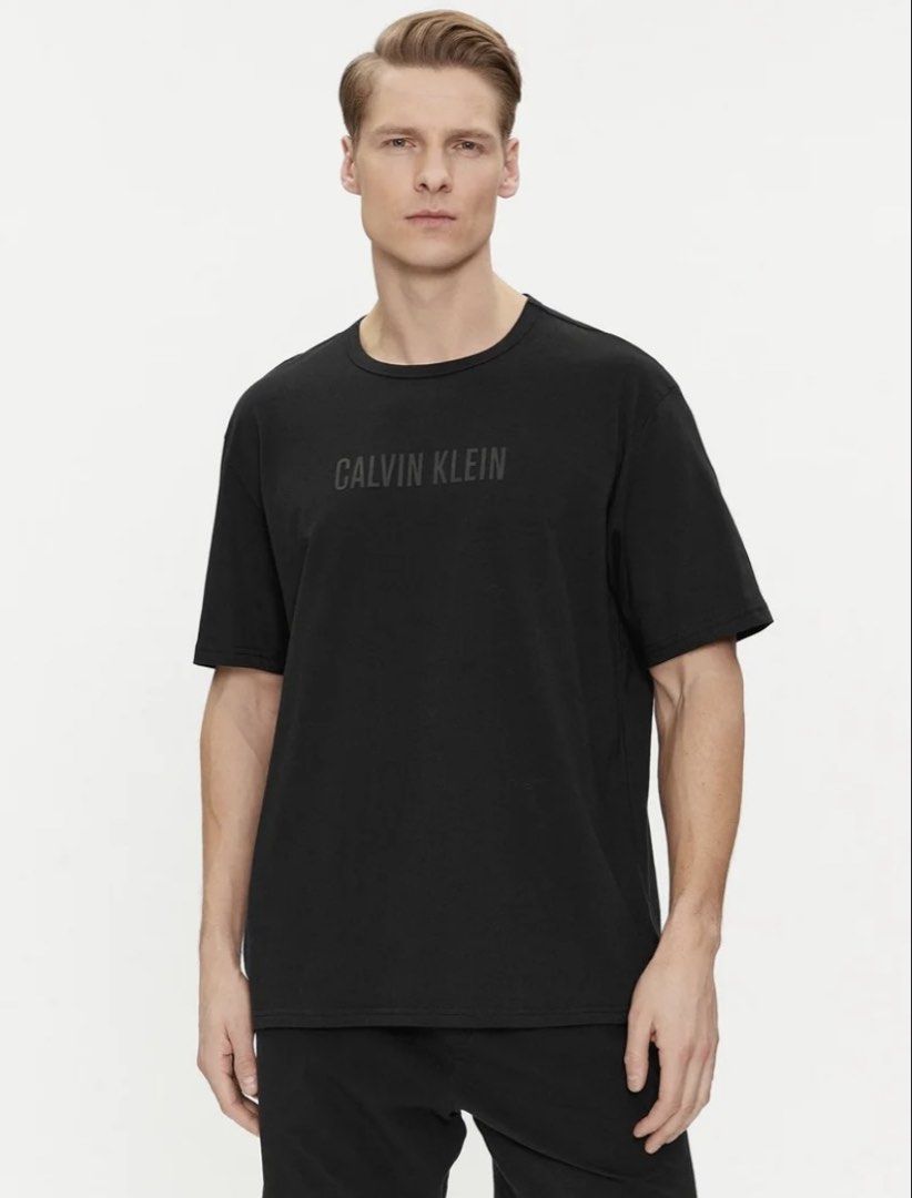 Calvin Klein Black Logo T-Shirt (Category: Activewear) located in Manila. Submitted by true_dailylifestyle (Listing ID 1470062446, Image 1). Description: - Brand: Calvin Klein - Color: Classic Black - Size: XXL (Regular Fit) - Design: Bold tonal chest logo with small 'ck' sleeve detail - Neckline: Crew neck - Style Code: J318288 - Condition: 100% authentic and well-maintained.
