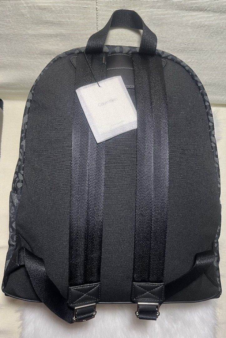 Calvin Klein Large Mono Canvas Black Grey Backpack (Category: Backpacks) located in Imus. Submitted by maria_pilayo (Listing ID 1469969025, Image 2). Description: - Brand: Calvin Klein - 💯% Authentic - Colorway: Black and Grey - Material/Design: All-over monogram canvas - Dimensions: 16" Height x 14" Width - Compartments: Front zip pocket - Features: Sturdy black shoulder straps and top handle - Condition: Brand new with original tag attached an