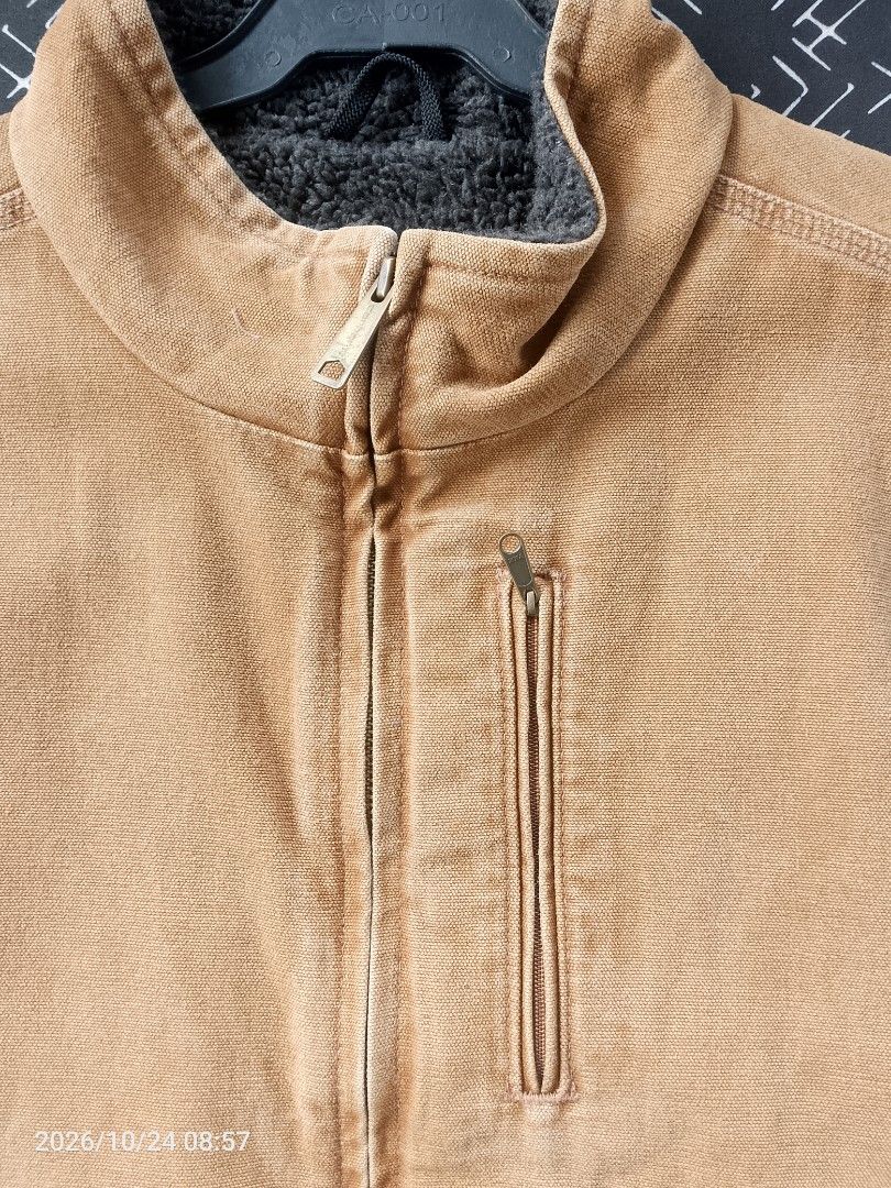 Carhartt Sherpa Lined Canvas Work Vest (Category: Vests) located in Bacolod City. Submitted by surfwear_in_negros (Listing ID 1469960463, Image 2). Description: - Brand/Style: Carhartt Duck Canvas Work Vest - Color: Classic Tan / Brown with Dark Grey Sherpa Fleece Lining - Features: Full zip front, stand-up collar, vertical chest zip pocket, and two large lower front pockets - Details: Iconic Carhartt square label on the lower pocket - Condition: