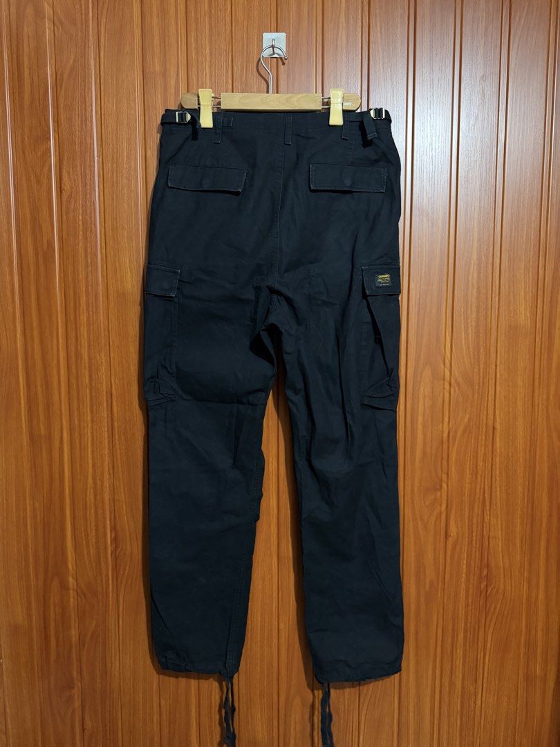 Carhartt WIP Black Cargo Pants (Category: Jeans) located in Manila. Submitted by tlfph (Listing ID 1470109488, Image 3). Description: - Brand: Carhartt WIP - Color: Black - Material: Tough, durable cotton built for daily wear - Pockets: Multiple utility pockets on sides and back - Fit: Adjustable waist tabs on both sides - Cuffs: Drawstring cuffs at the ankles - Branding: Classic woven Carhartt logo patch on the right cargo pocket.