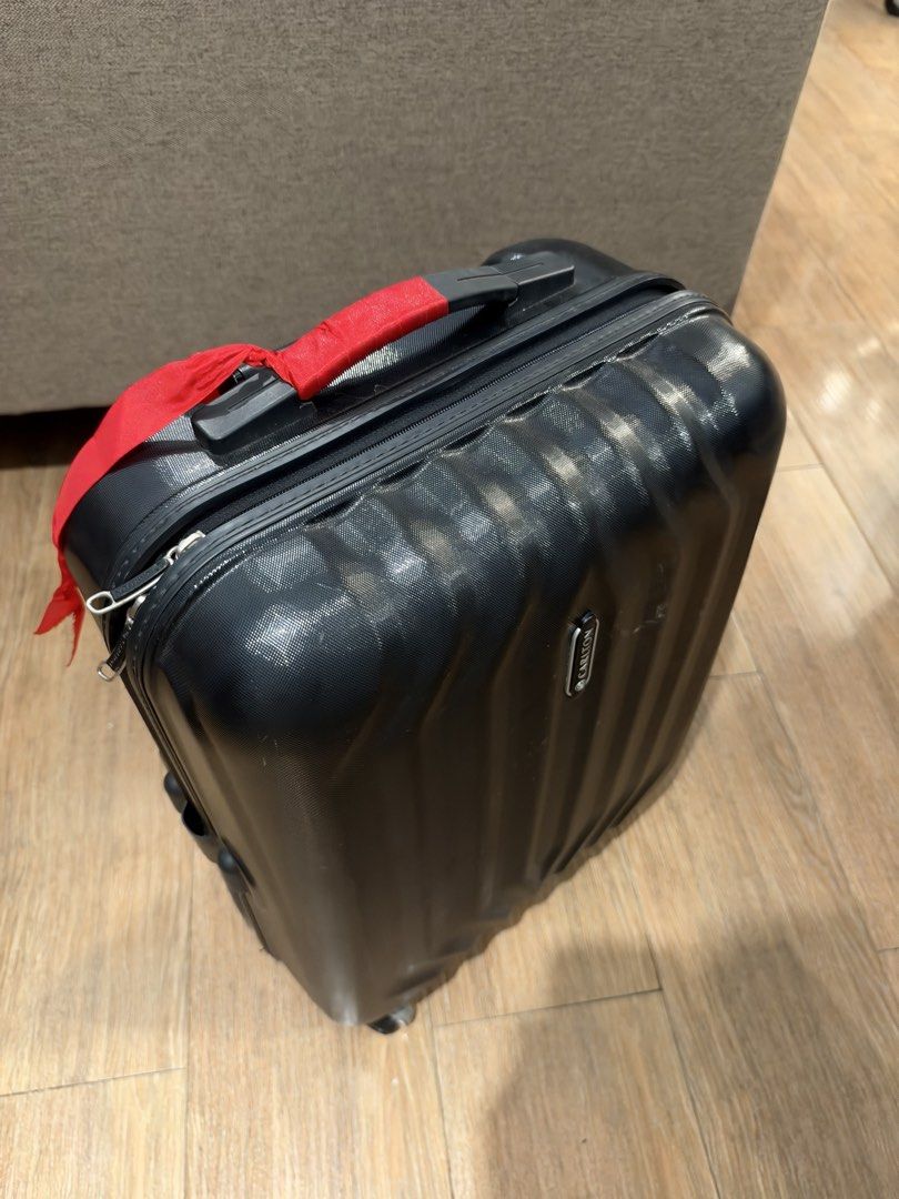 Carlton Black Hard Shell Luggage Suitcase (Category: Luggage) located in Manila. Submitted by garagesalebykoda (Listing ID 1470054316, Image 2). Description: Carlton hard shell luggage in black. Textured vertical striped exterior. Includes built-in TSA002 combination lock and smooth-rolling spinner wheels. Retractable top handle equipped with a red fabric tie for quick identification at baggage claim. Zippers operate smoothly. Normal light scuffs