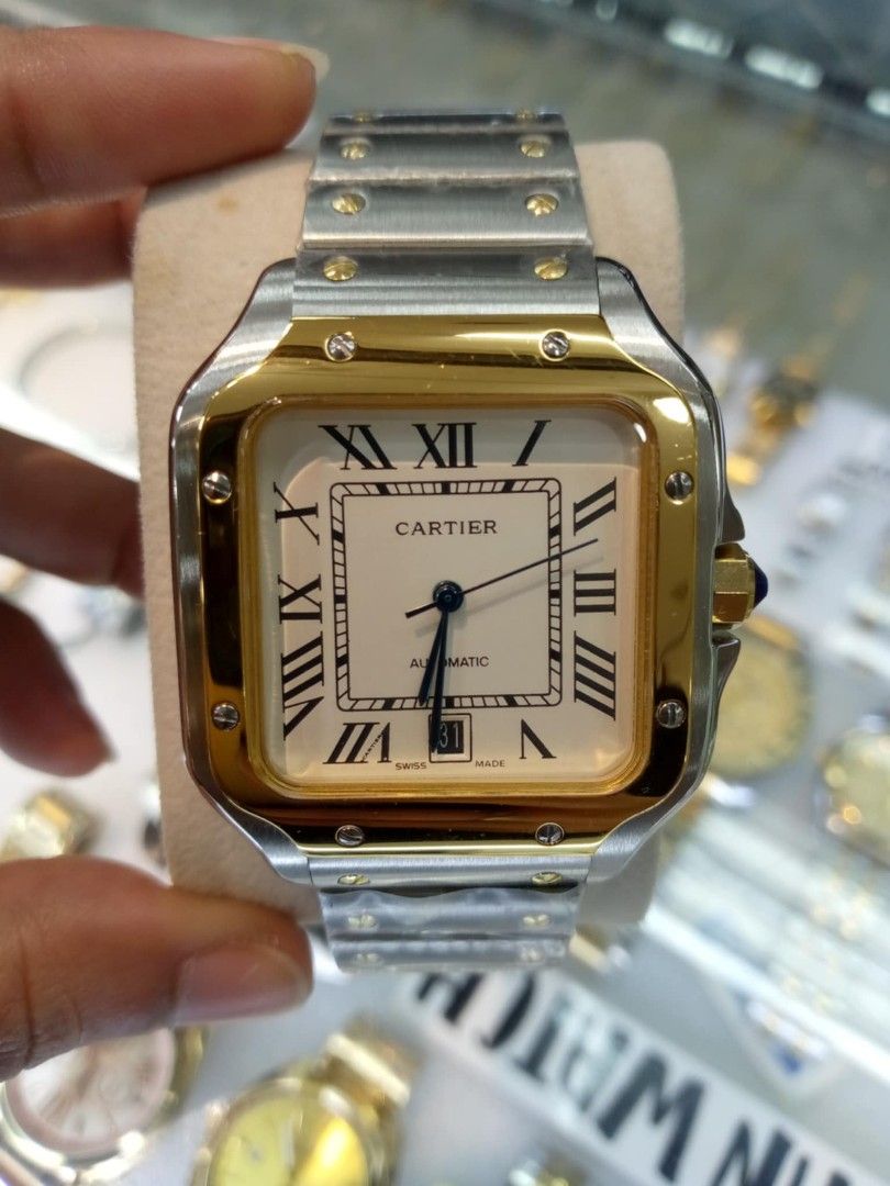 Cartier Santos Automatic Watch (Category: Luxury Watches) located in Las Pinas. Submitted by teampeewee888 (Listing ID 1470015895, Image 2). Description: - Model: Cartier Santos Automatic - Case & Bracelet: Stainless steel with protective plastic wraps still on links - Dial Features: Classic Roman numeral markers, date window near the bottom edge, and multiple color variants available - Movement: Automatic - Special Detail: Crown fitted with a si