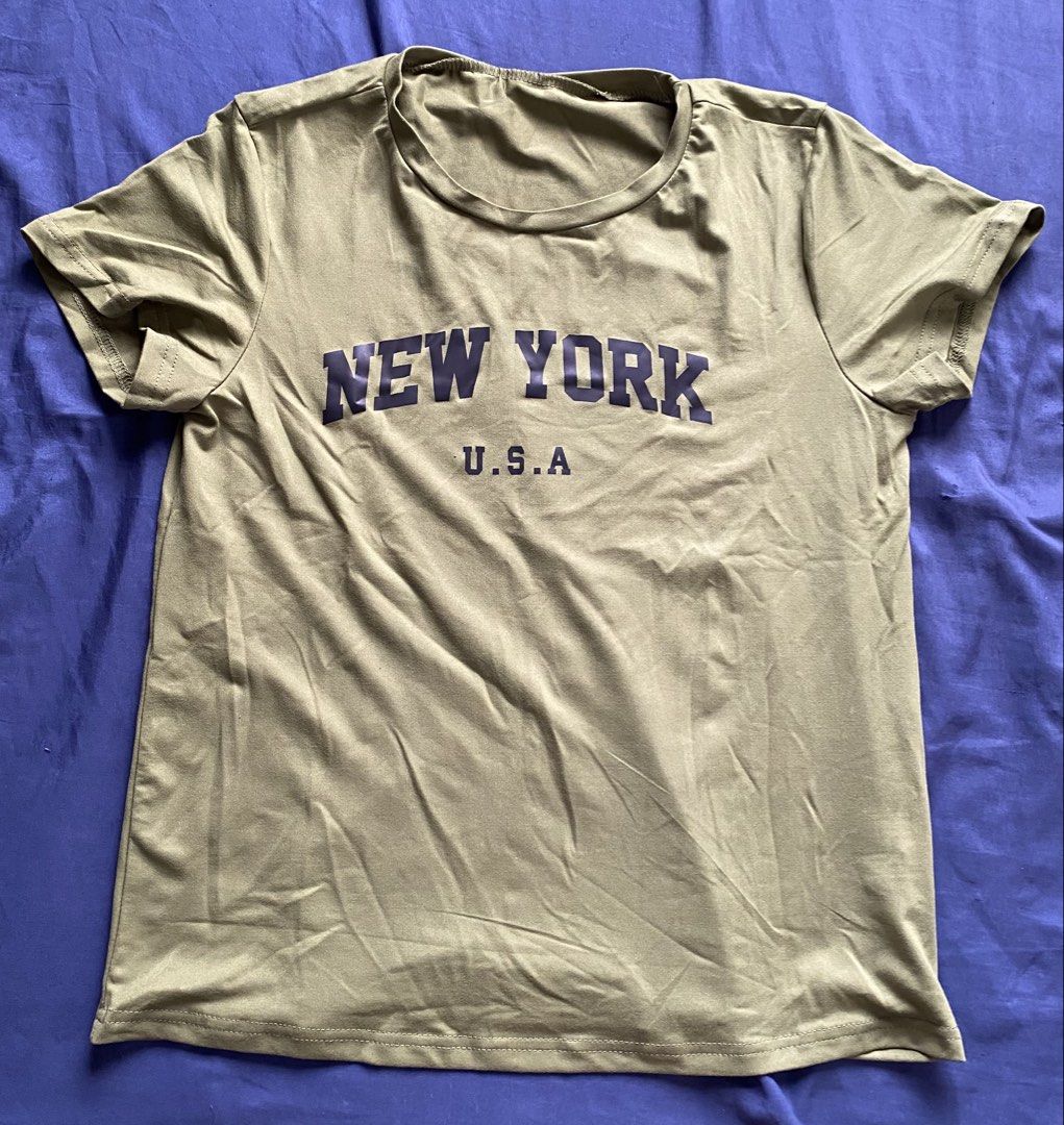 Casual Graphic Print T-shirts Bundle / Individual (Category: Shirts) located in Manila. Submitted by livebear-e9f3 (Listing ID 1470017784, Image 1). Description: - Set of 4 casual crewneck t-shirts made from a soft cotton blend - Olive green tee with 'New York USA' print - White tee featuring a black rose design on the chest - Black jersey-style tee with 'Rocknrolla 23' and white stripes - Pink and black colorblock top with 'New York 1968' letter