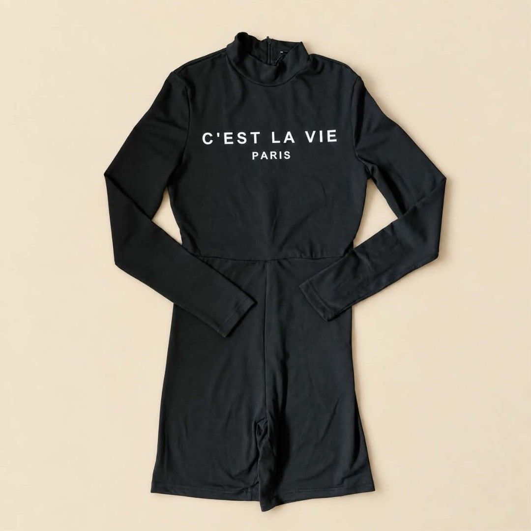C'est La Vie Paris Black Long Sleeve Romper (Category: Rompers) located in Manila. Submitted by joshbelgic17602 (Listing ID 1469969340, Image 1). Description: - Color: Black with white 'C'EST LA VIE PARIS' chest lettering - Style: Long sleeve romper with mock neck and short shorts length - Fit: Fitted design with stretchy fabric for comfort - Closure: Convenient back zipper.