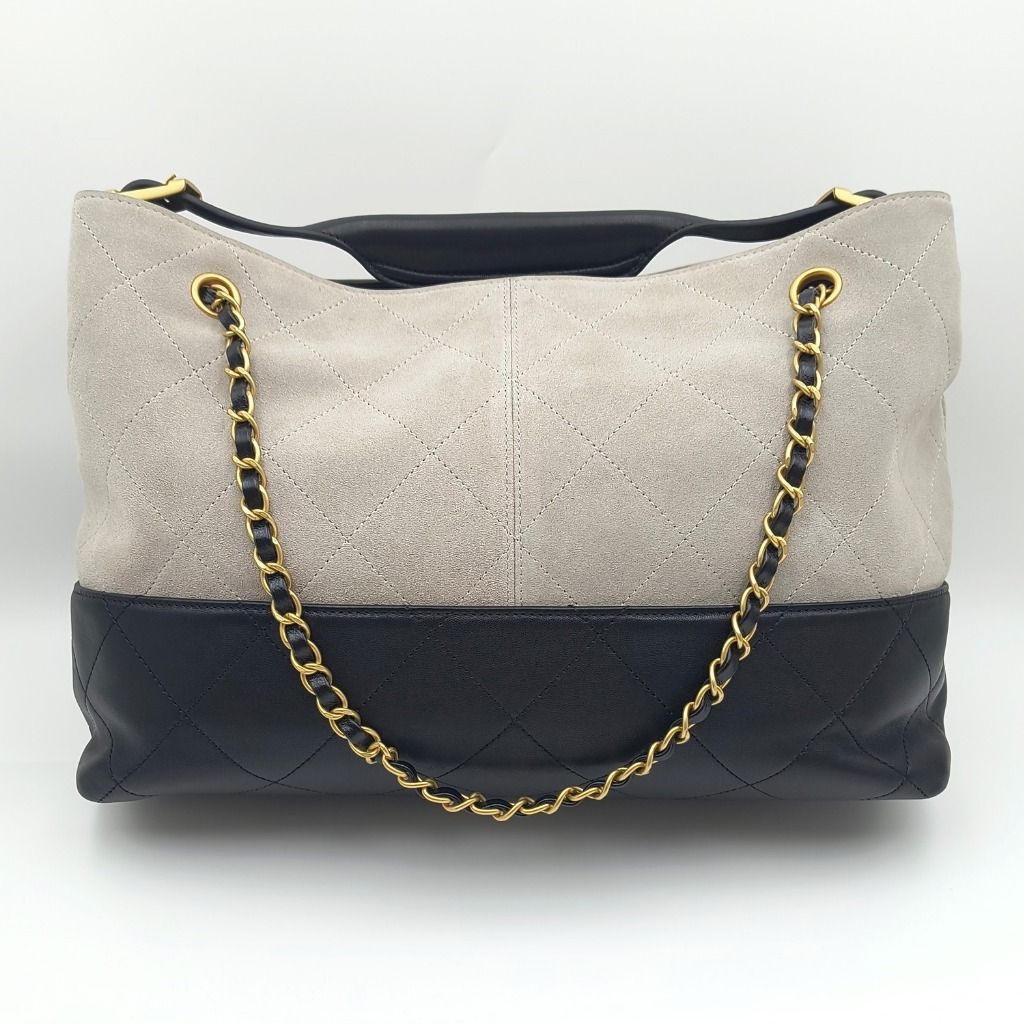 Chanel 25A Coco Shopping Bag Small Grey Black (Category: Luxury Bags & Wallets) located in Cebu City. Submitted by affordabagss (Listing ID 1470003666, Image 3). Description: Chanel 25A Coco Shopping Bag crafted in grey quilted suede with contrasting black quilted lambskin leather along the base. Accented with gold-tone CC hardware, leather-interwoven chain detailing, and an adjustable black leather shoulder handle. The spacious open-top silhouet