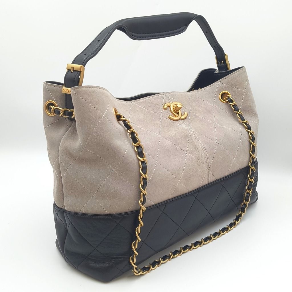 Chanel 25A Coco Shopping Bag Small Grey Black (Category: Luxury Bags & Wallets) located in Cebu City. Submitted by affordabagss (Listing ID 1470003666, Image 2). Description: Chanel 25A Coco Shopping Bag crafted in grey quilted suede with contrasting black quilted lambskin leather along the base. Accented with gold-tone CC hardware, leather-interwoven chain detailing, and an adjustable black leather shoulder handle. The spacious open-top silhouet