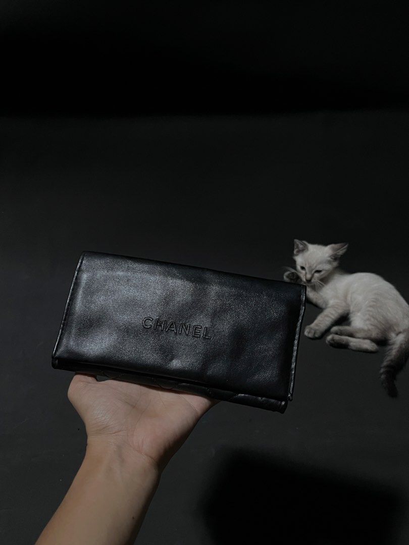 CHANEL Black Quilted Leather Wallet with Embossed Logo (Category: Wallets & Card holders) located in Andop. Submitted by outclickz_00 (Listing ID 1470119208, Image 1). Description: - Brand: CHANEL - Material: Smooth black leather with clean edges - Design: Quilted diamond pattern on the back and embossed CHANEL lettering on the front flap - Closure: Secure flap closure opening to a spacious interior - Note: Cat shown in photos is cute, but defini