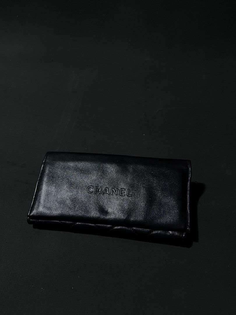 CHANEL Black Quilted Leather Wallet with Embossed Logo (Category: Wallets & Card holders) located in Andop. Submitted by outclickz_00 (Listing ID 1470119208, Image 2). Description: - Brand: CHANEL - Material: Smooth black leather with clean edges - Design: Quilted diamond pattern on the back and embossed CHANEL lettering on the front flap - Closure: Secure flap closure opening to a spacious interior - Note: Cat shown in photos is cute, but defini