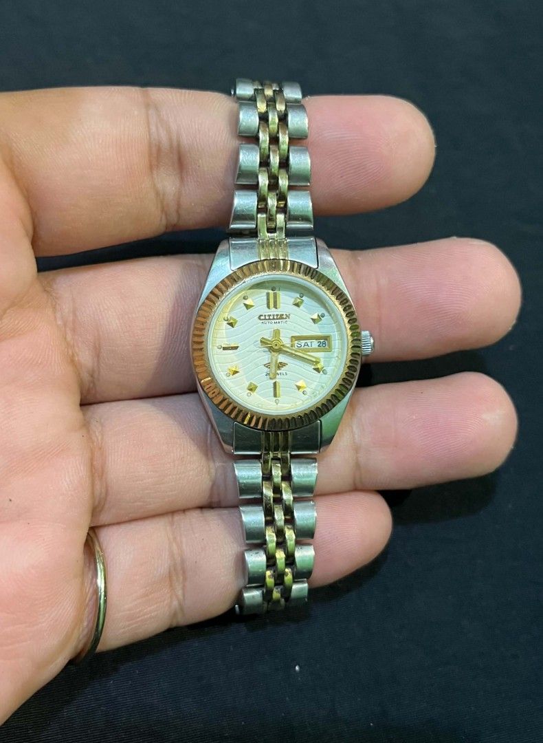 Citizen Automatic Two-Tone Ladies Watch (Category: Women's Watches) located in Cebu City. Submitted by jbok_watches. (Listing ID 1470103179, Image 2). Description: - Brand: Citizen Automatic Watch - Dial: Textured white with gold-tone hour markers & day-date window at 3 o'clock - Bezel: Fluted design in gold-tone - Bracelet: Two-tone steel and gold jubilee bracelet with signed folding clasp - Caseback: Stainless steel with engraved model text - C