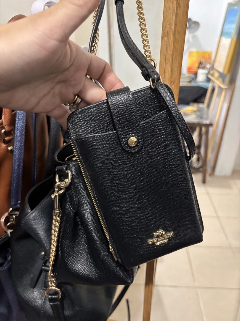 Coach Black Leather Phone Crossbody Bag (Category: Cross-body Bags) located in Quezon City. Submitted by warmfalcon_3ce574 (Listing ID 1470096009, Image 2). Description: - Brand: Coach - Color: Classic Black - Material: Premium textured leather - Hardware: Elegant gold-tone accents with stylish chain details - Pockets: Front flap pocket with snap closure and a secure zip pocket - Strap: Detachable strap for versatile styling - Size: Compact and p