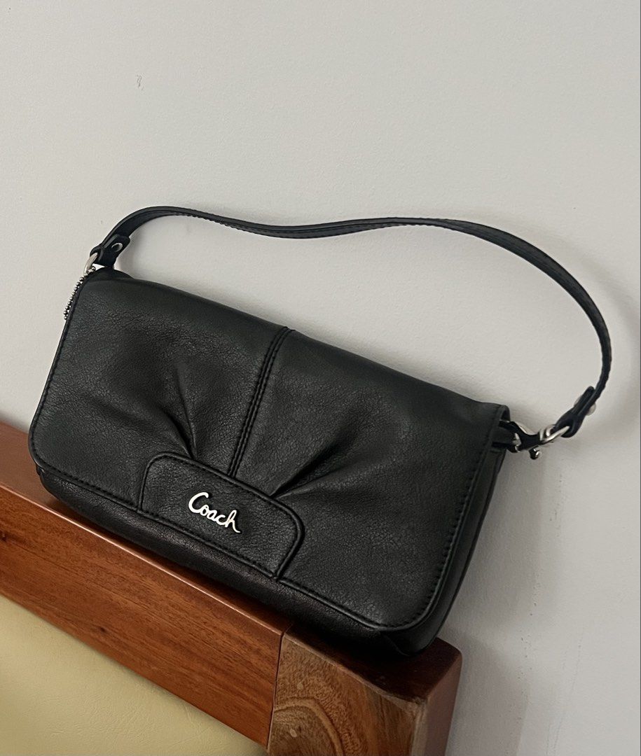 Coach Black Leather Shoulder Bag Wristlet (Category: Luxury Bags & Wallets) located in Makati City. Submitted by lovedbyliv_ (Listing ID 1469947706, Image 1). Description: - Brand: Coach - Material: Classic black leather - Hardware: Silver-tone - Closure: Structured flap with snap button - Interior: Fabric lining with multiple card slots - Strap: Removable single strap - Inclusion: Detachable Coach hangtag - Condition: Clean silhouette, compact s