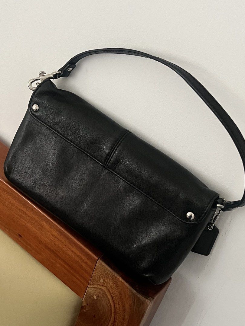 Coach Black Leather Shoulder Bag Wristlet (Category: Luxury Bags & Wallets) located in Makati City. Submitted by lovedbyliv_ (Listing ID 1469947706, Image 3). Description: - Brand: Coach - Material: Classic black leather - Hardware: Silver-tone - Closure: Structured flap with snap button - Interior: Fabric lining with multiple card slots - Strap: Removable single strap - Inclusion: Detachable Coach hangtag - Condition: Clean silhouette, compact s