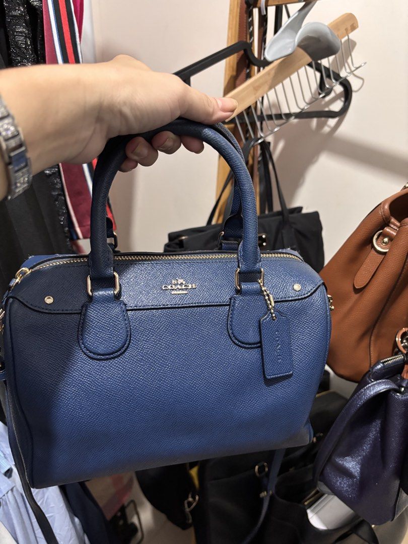 Coach Blue Leather Satchel Handbag (Category: Luxury Bags & Wallets) located in Quezon City. Submitted by warmfalcon_3ce574 (Listing ID 1470095812, Image 2). Description: - Brand: Coach - Style: Compact structured satchel handbag - Color: Blue with elegant gold-tone hardware - Material: Premium textured leather - Closure: Secure top zipper closure - Handles: Dual carry handles with matching hangtag included - Base: Features protective metal studs
