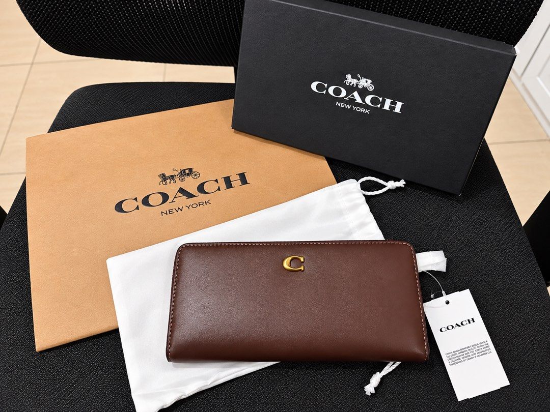Coach Brass/Maple Leather Long Wallet with Gold C Logo (Category: Luxury Bags & Wallets) located in Lipa City. Submitted by soojinkmh (Listing ID 1470103427, Image 1). Description: COACH Essential Slim Wallet – Brass/Maple RFS: Decluttering / Not being used Price: ₱13,000 (Slightly negotiable) Condition: Brand New Details: * Material: Refined calf leather * Gold Coach “C” logo * Snap closure * 12 credit card slots * Full-length bill compartments 