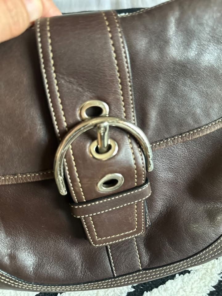 Coach Brown Leather Shoulder Bag (Category: Luxury Bags & Wallets) located in Cebu City. Submitted by isellhere123.543 (Listing ID 1469984128, Image 2). Description: - Authentic Coach shoulder bag in rich brown full-grain leather - Secure magnetic snap closure beneath the front buckle strap - Comfortable adjustable buckle handle - Clean brown fabric interior with creed patch numbered F10192 - Maintains a structured shape with minor natural grain 