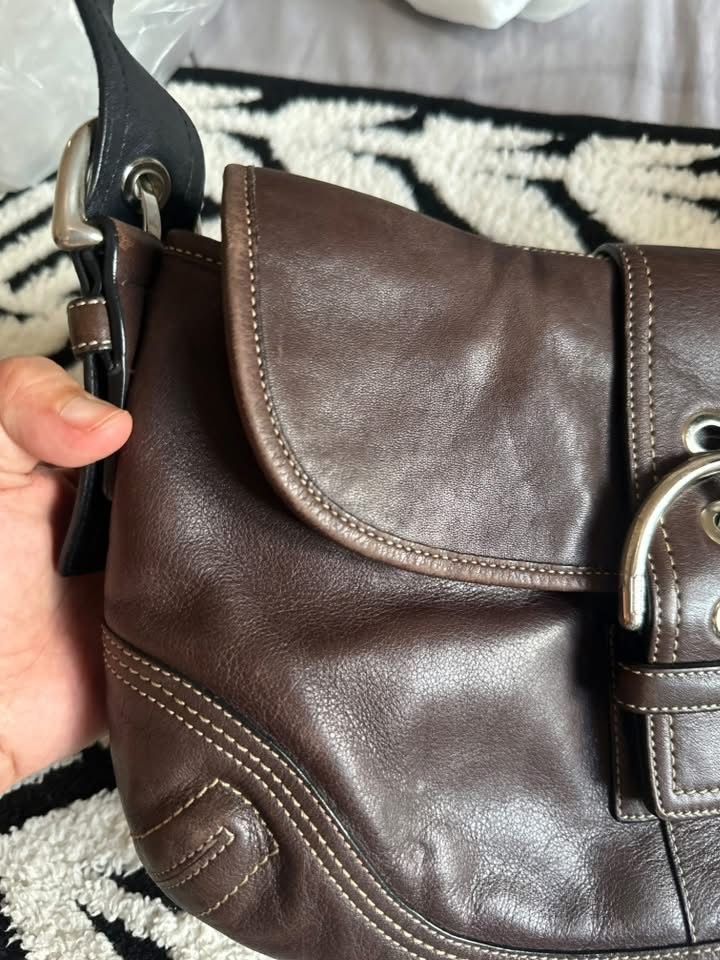 Coach Brown Leather Shoulder Bag (Category: Luxury Bags & Wallets) located in Cebu City. Submitted by isellhere123.543 (Listing ID 1469984128, Image 3). Description: - Authentic Coach shoulder bag in rich brown full-grain leather - Secure magnetic snap closure beneath the front buckle strap - Comfortable adjustable buckle handle - Clean brown fabric interior with creed patch numbered F10192 - Maintains a structured shape with minor natural grain 