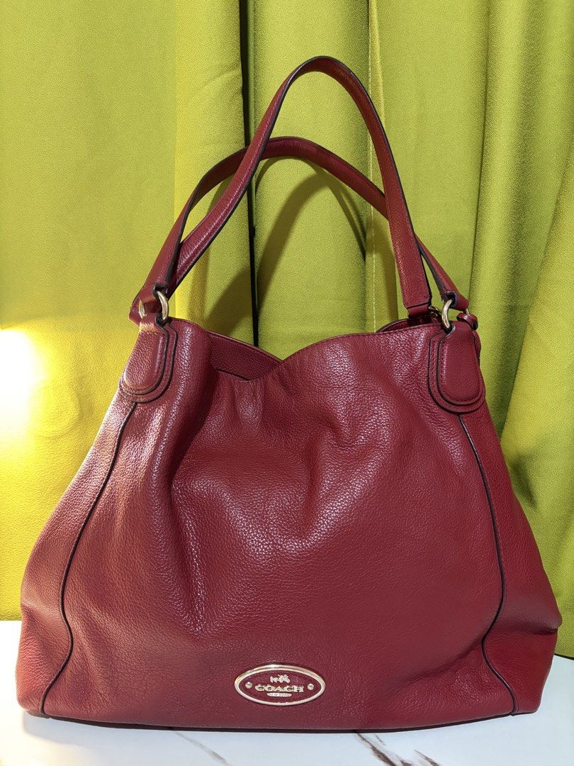 Coach Edie Shoulder Bag (Category: Shoulder Bags) located in Borongan. Submitted by charmspreloveddd (Listing ID 1470022060, Image 1). Description: - Authentic Coach red pebble leather shoulder bag - Style Number: 33547 - Elegant gold-tone hardware and iconic oval Coach New York logo plaque - Dual top handles and secure top zip closure - Spacious interior lined in red fabric with functional zip and slip pockets - L:35cm (bottom) 23cm (top) W:14cm