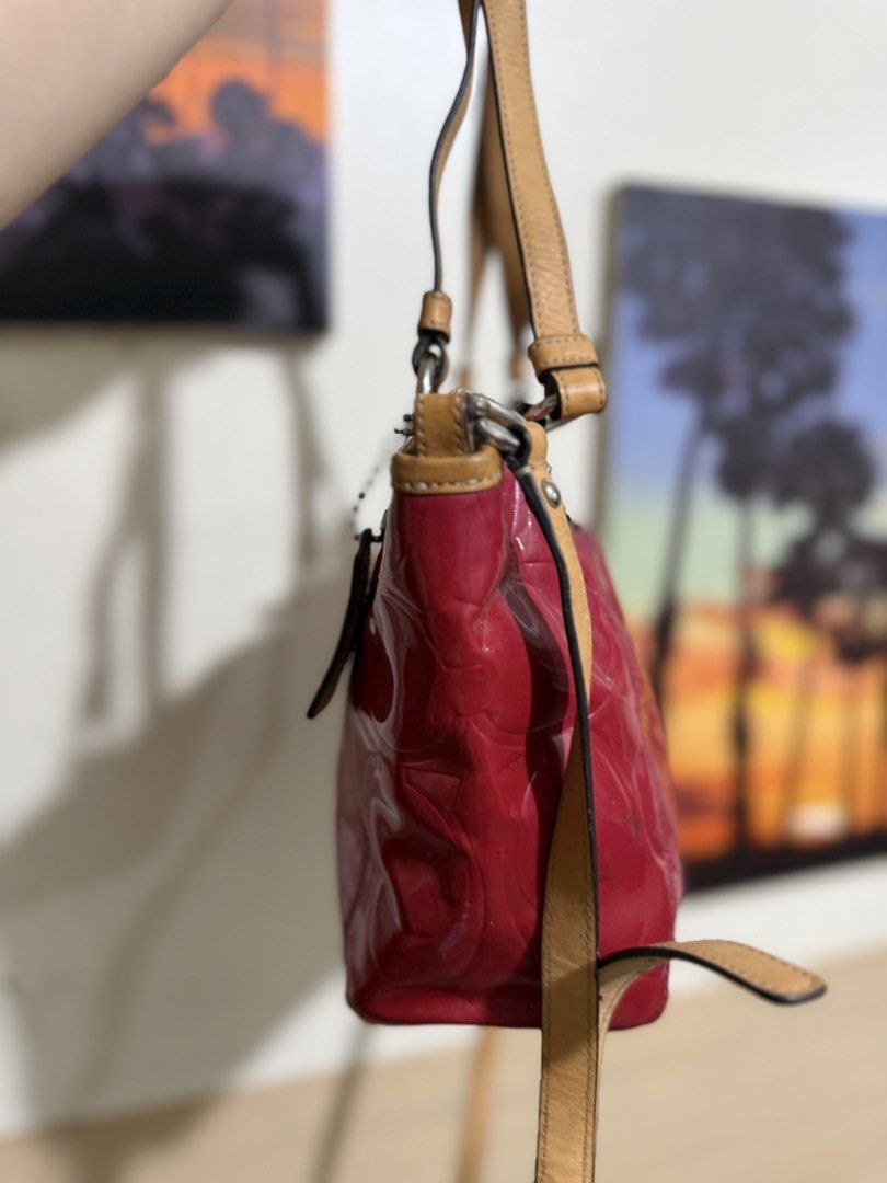 Coach Patent Leather Red Tote Bag (Category: Tote Bags) located in Quezon City. Submitted by vianca13 (Listing ID 1470033878, Image 2). Description: - Brand: Coach - Material: Red patent leather with debossed signature C pattern and tan leather trim - Carry Options: Dual top handles and an optional shoulder strap - Exterior Details: Front slip pocket with turnlock accent and hanging leather tag - Interior Details: Cream fabric lining with zipper 