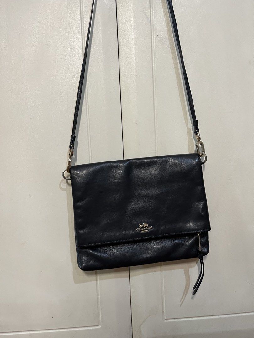 Coach Slim Leather Foldover Crossbody Bag (Category: Luxury Bags & Wallets) located in Makati City. Submitted by sodypop88 (Listing ID 1469953084, Image 1). Description: - Authentic Coach black leather crossbody bag - Features elegant gold-tone hardware and embossed gold carriage logo - Secure foldover flap closure with main zipper compartment - Signature C fabric interior lining with built-in card slots - Comfortable adjustable leather strap - P
