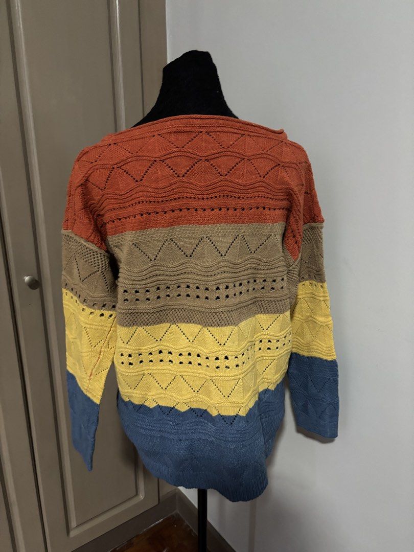 Colorblock Knit Sweater Multicolor Striped Pullover (Category: Longsleeves) located in Quezon City. Submitted by ada_412 (Listing ID 1470128496, Image 2). Description: - Style: Multi-colored knit sweater with a relaxed fit - Pattern: Striped with open-knit geometric and chevron details - Colors: Rust orange, taupe, yellow, and denim blue - Design: Wide neckline and long sleeves - Material: Soft and comfortable knit fabric.