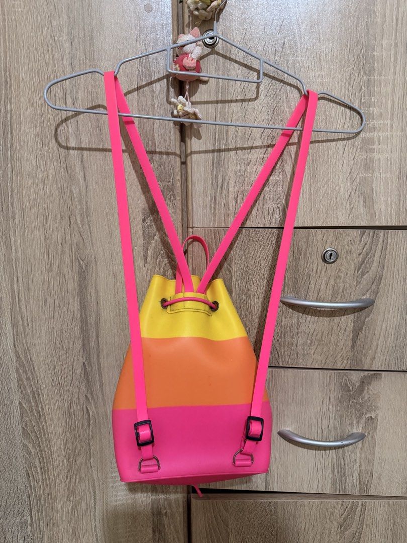 Colorful silicone bucket backpack pink orange yellow drawstring (Category: Backpacks) located in Manila. Submitted by tenshiii185 (Listing ID 1470056314, Image 2). Description: Bright tri-color silicone backpack in yellow, orange, and pink. Features a drawstring closure, black toggle, and adjustable pink straps. Fun, waterproof-texture everyday bag!.