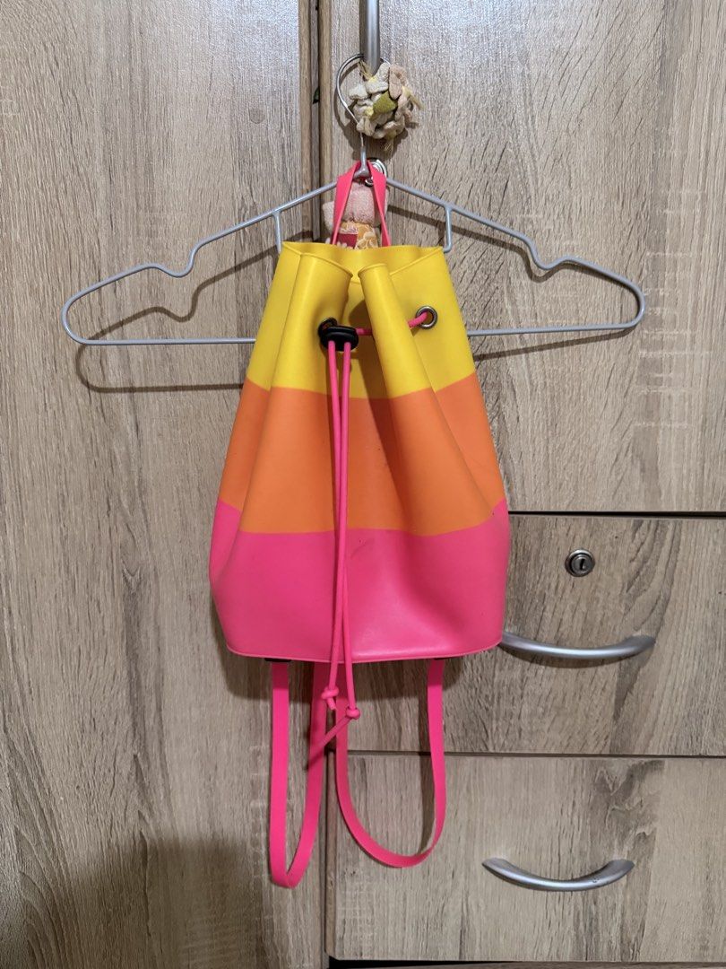 Colorful silicone bucket backpack pink orange yellow drawstring (Category: Backpacks) located in Manila. Submitted by tenshiii185 (Listing ID 1470056314, Image 1). Description: Bright tri-color silicone backpack in yellow, orange, and pink. Features a drawstring closure, black toggle, and adjustable pink straps. Fun, waterproof-texture everyday bag!.